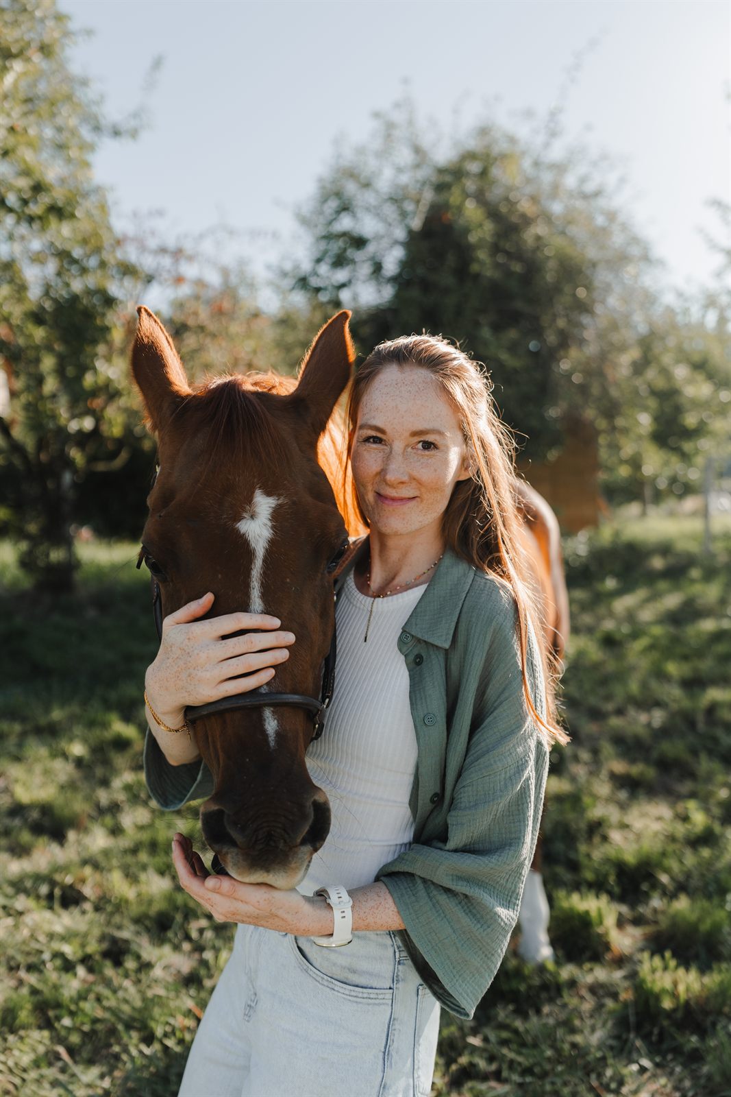 Jenny Dias mit ihrem Pferd auf einer sonnigen Wiese
