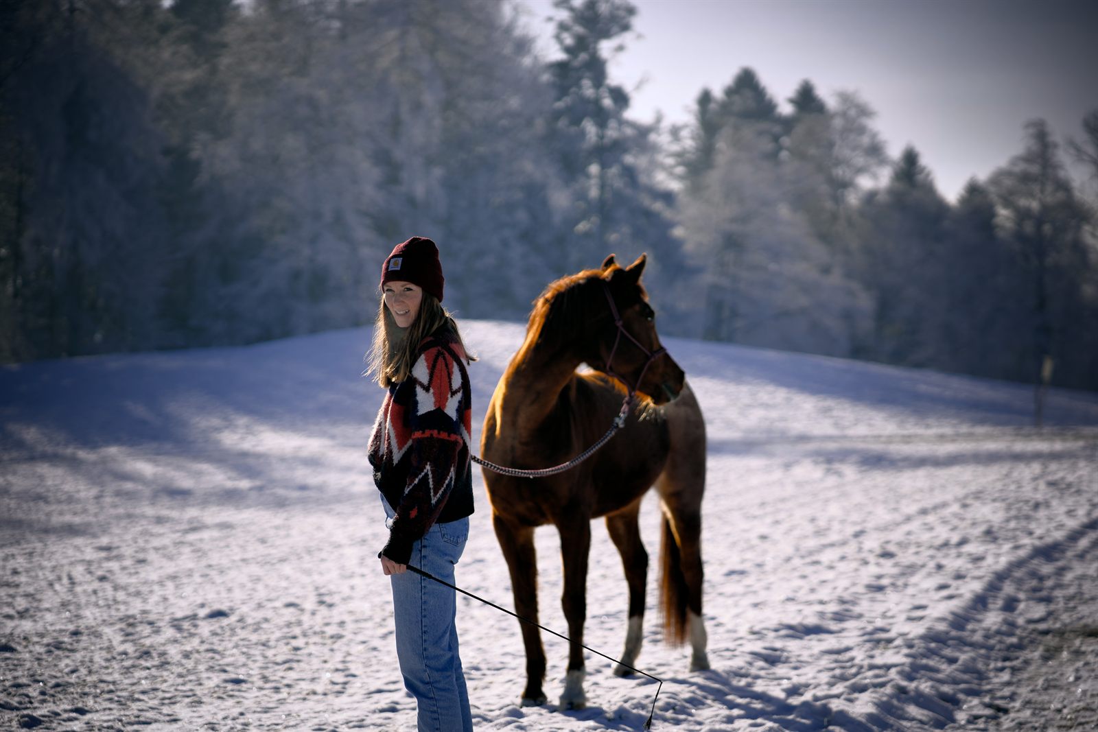 Jenny Dias mit ihrem Pferd auf einer verschneiten Weide